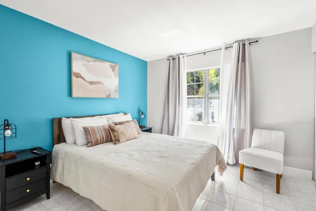 a bedroom with a bed and a large window