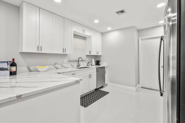 a kitchen with stainless steel appliances granite countertop a stove a refrigerator and a microwave