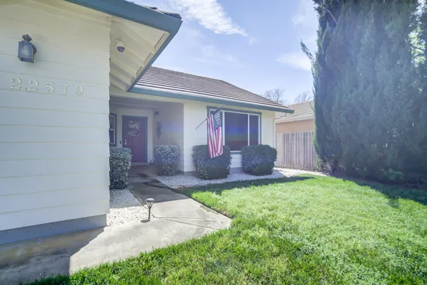 a view of a house with a yard and pathway
