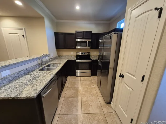 a large kitchen with a stove a refrigerator and a sink