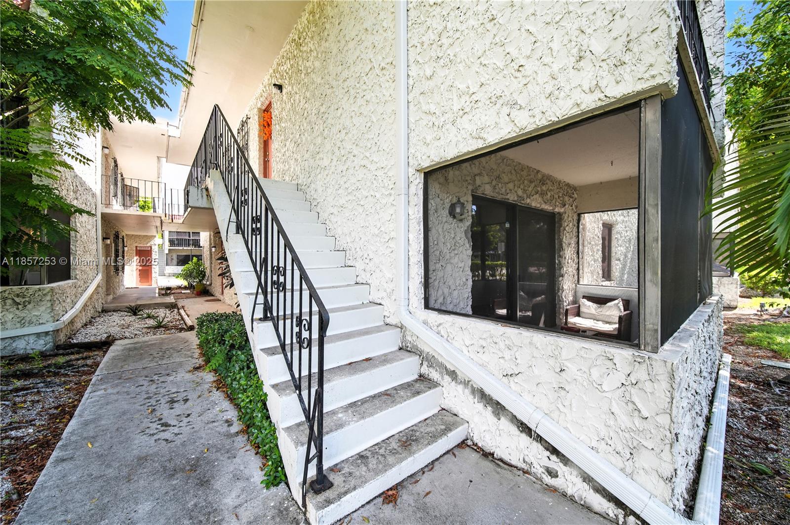 8701 Southwest 141st Street, Unit B1 Miami, FL 33176 - Photo 12 of 22 a view of a house with backyard and trees