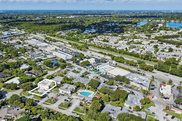 an aerial view of residential houses with outdoor space and trees