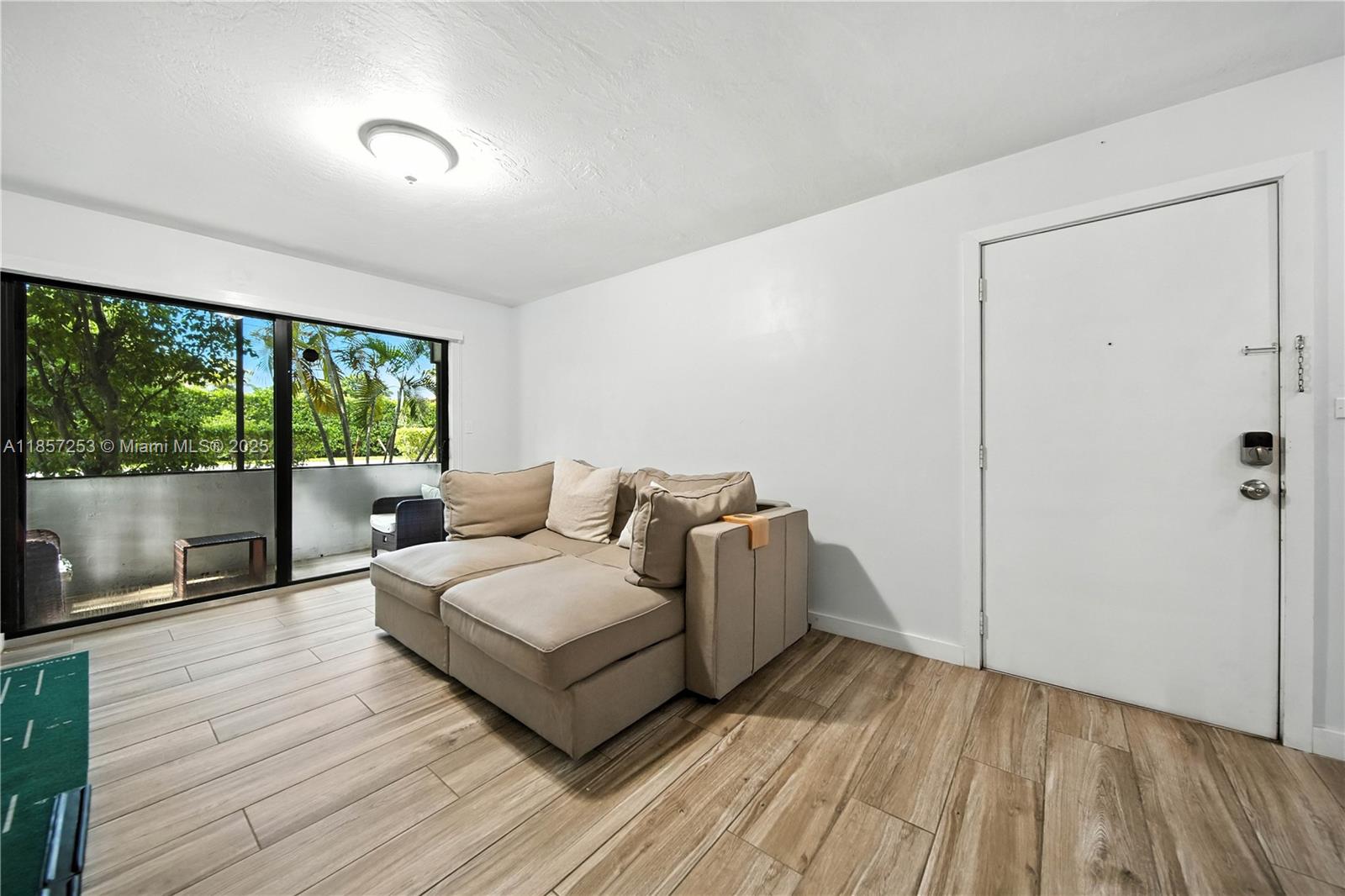 8701 Southwest 141st Street, Unit B1 Miami, FL 33176 - Photo 2 of 22 a living room with a bed furniture large window and wooden floor