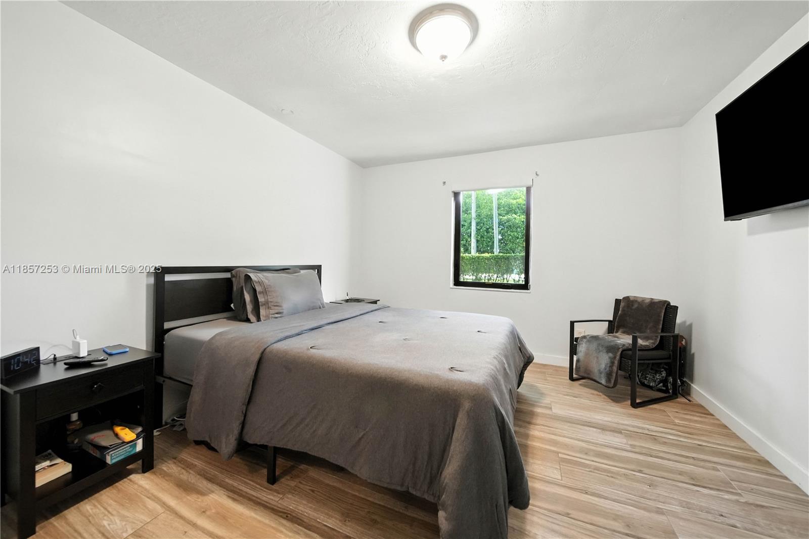 8701 Southwest 141st Street, Unit B1 Miami, FL 33176 - Photo 7 of 22 a bedroom with a bed and a television