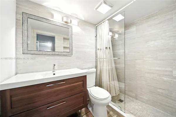 a bathroom with a sink a toilet and shower