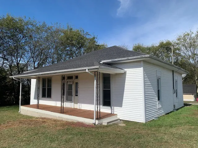 a view of a white house with a yard