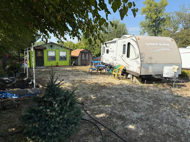 a view of a white house with large trees