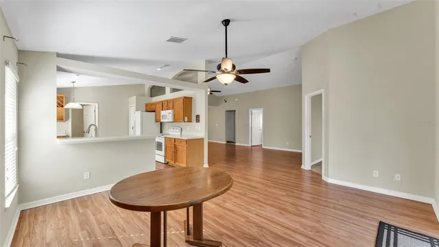a dining room with wooden floor a chandelier a wooden table and chairs