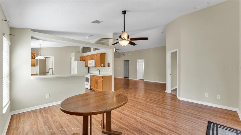3588 Raleigh Drive Winter Haven, FL 33884 - Photo 11 of 40 a dining room with wooden floor a chandelier a wooden table and chairs