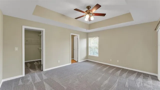 an empty room with a ceiling fan and a window