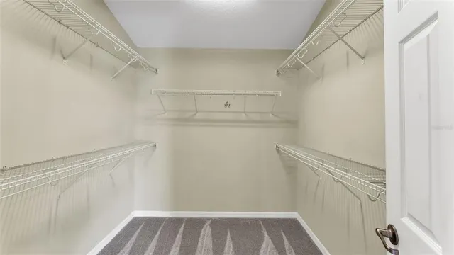 a view of walk in closet with empty racks