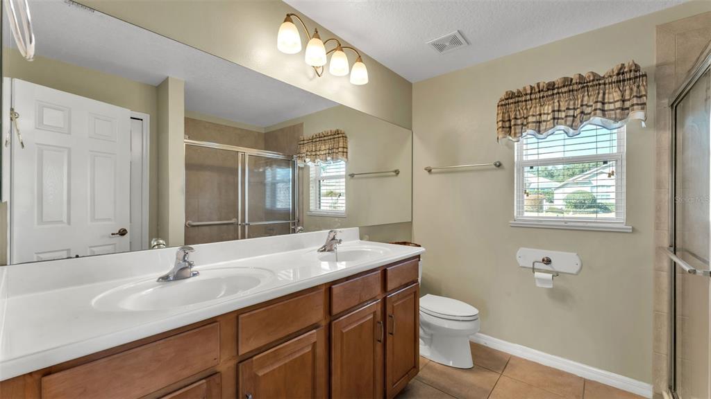 3588 Raleigh Drive Winter Haven, FL 33884 - Photo 22 of 40 a bathroom with a sink a toilet a mirror and shower