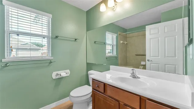 a bathroom with a granite countertop sink a toilet and a mirror