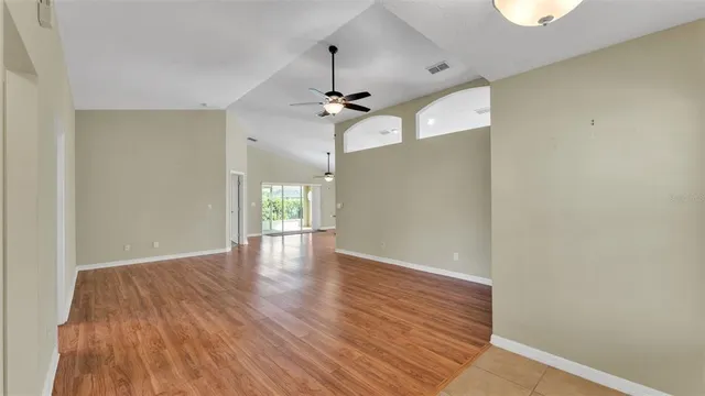 a view of an empty room with window and wooden floor