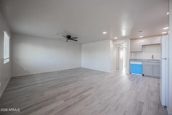 wooden floor in an empty room with a kitchen