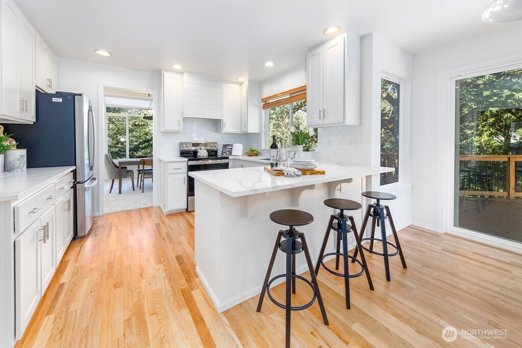 1065 Southwest 12th Street North Bend, WA 98045 - Photo 6 of 27 a kitchen with stainless steel appliances kitchen island a large window and wooden floor