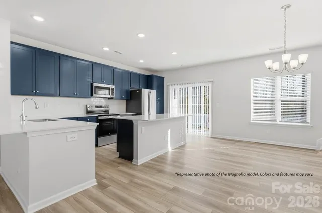 a kitchen with kitchen island a refrigerator sink and wooden cabinets