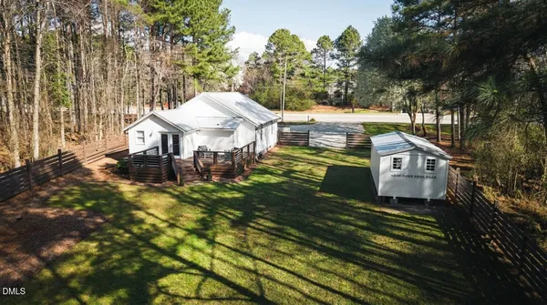 a aerial view of a house with a big yard plants and large trees