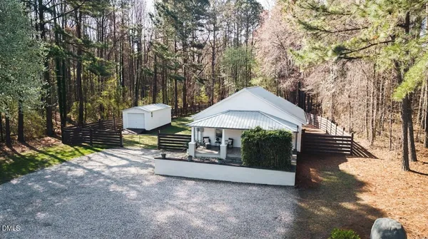a view of a house with backyard and trees