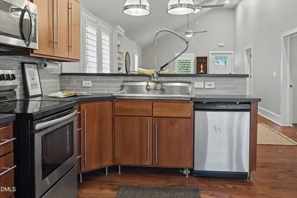 a kitchen with stainless steel appliances granite countertop a sink and a stove
