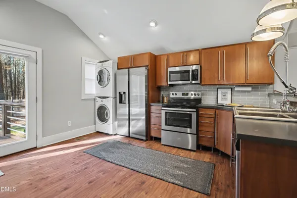 a kitchen with granite countertop a refrigerator and a stove top oven