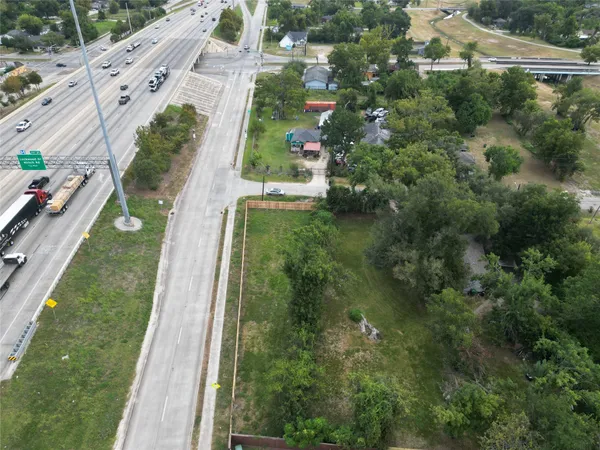 an aerial view of residential houses with outdoor space and trees