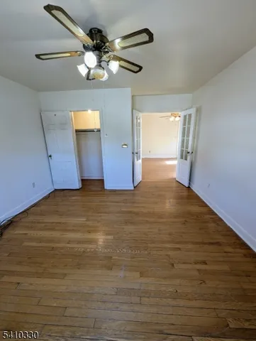 a view of a big room with a ceiling fan and window
