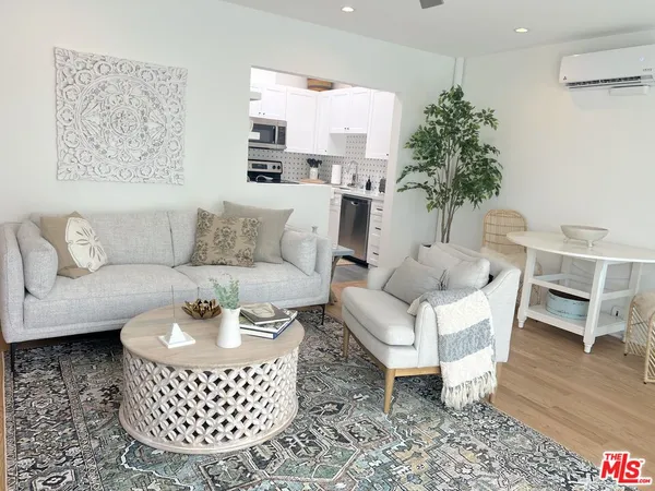 a living room with furniture a dining table and a potted plant