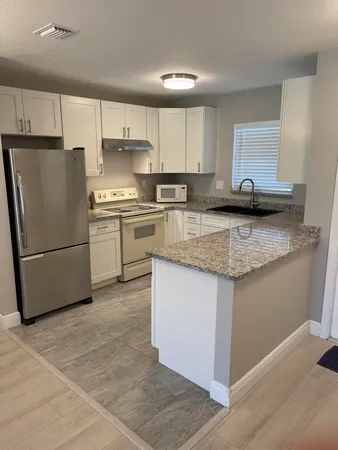 a kitchen with stainless steel appliances granite countertop a stove a sink a refrigerator and a granite counter tops