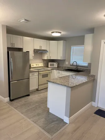 a kitchen with stainless steel appliances granite countertop a refrigerator sink and stove