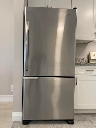 a view of a refrigerator in kitchen and cabinets