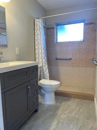 a bathroom with a granite countertop sink toilet and shower
