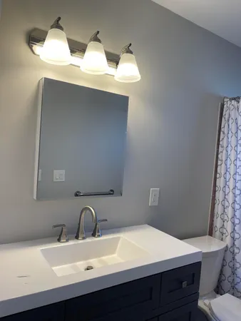 a bathroom with a sink vanity mirror and toilet