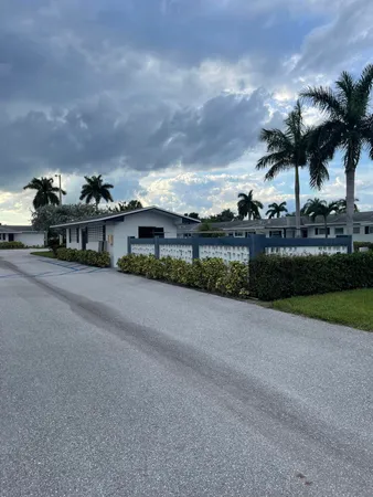 a view of a house with a yard and potted plants