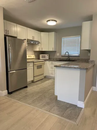 a kitchen with granite countertop a sink stainless steel appliances and cabinets