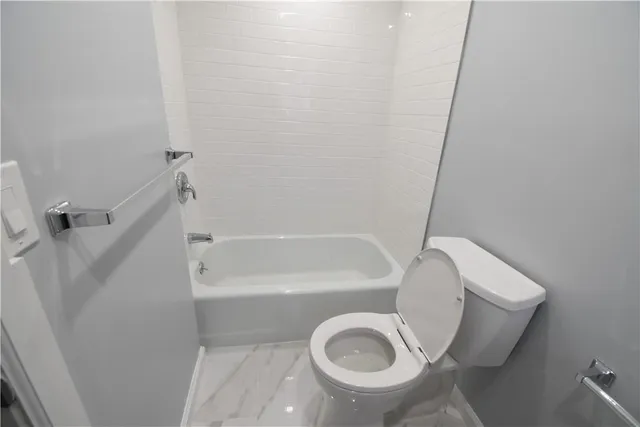 a bathroom with a toilet and a tub
