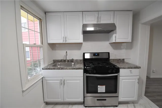 a kitchen with white cabinets and appliances