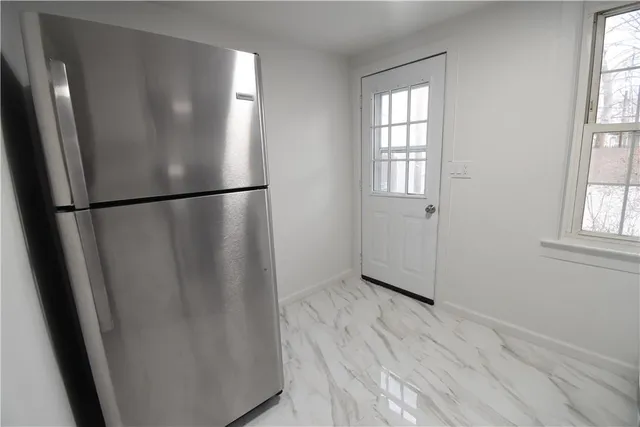 a view of empty room with wooden floor and window