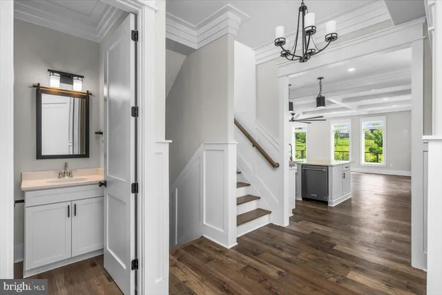 a view of empty room with wooden floor and kitchen view