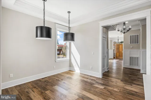 a view of a kitchen with white cabinets and wooden floor