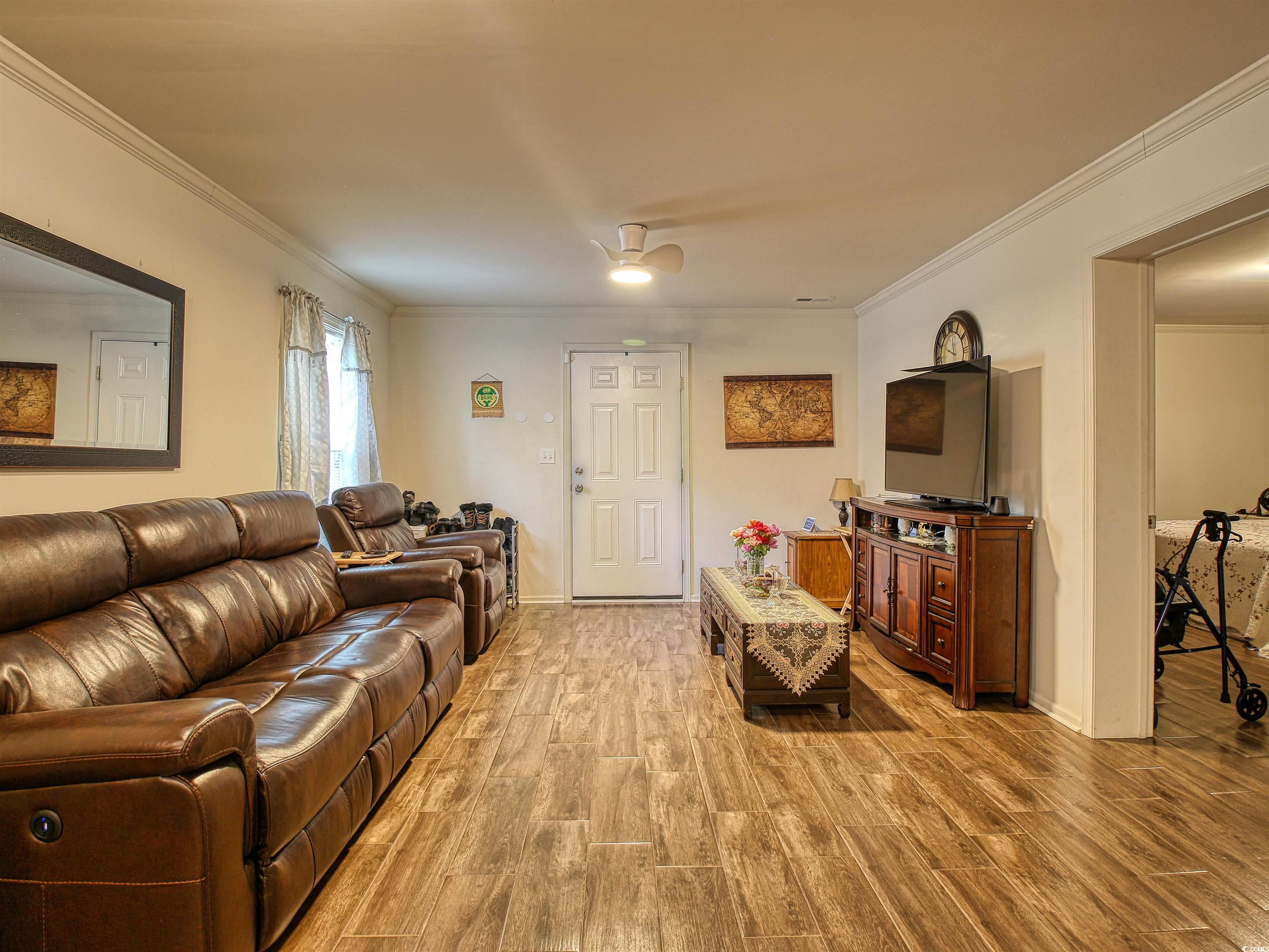 215 West James Street Mullins, SC 29574 - Photo 4 of 18 Living room featuring light wood finished floors and crown molding