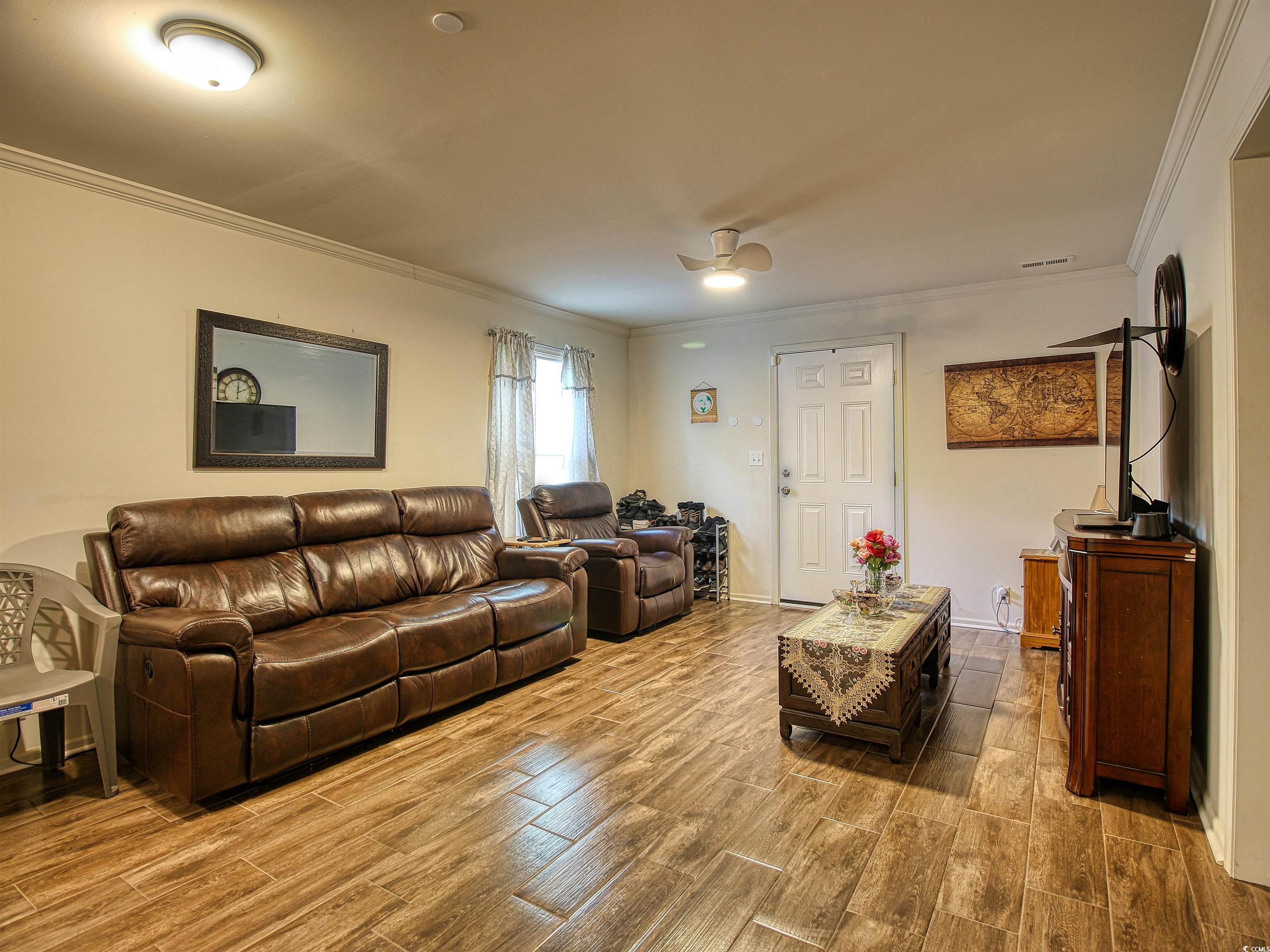 215 West James Street Mullins, SC 29574 - Photo 6 of 18 Living room featuring ornamental molding and light wood-style floors