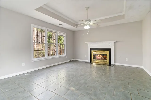 an empty room with windows and ceiling fan