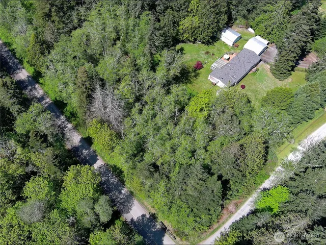 an aerial view of residential house with outdoor space and trees all around