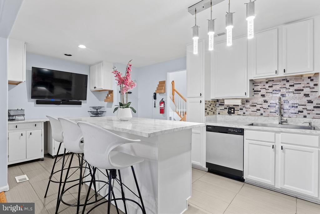 10335 Citation Way Ruther Glen, VA 22546 - Photo 11 of 47 a kitchen with kitchen island granite countertop a sink and white cabinets