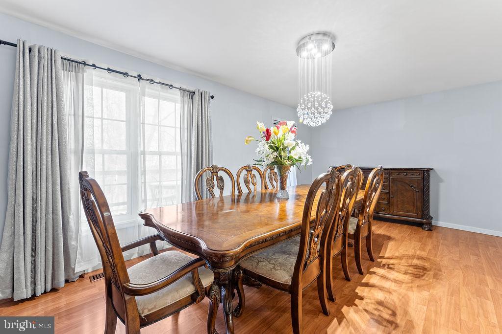 10335 Citation Way Ruther Glen, VA 22546 - Photo 13 of 47 a dining room with furniture a chandelier and wooden floor