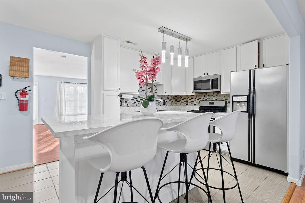 10335 Citation Way Ruther Glen, VA 22546 - Photo 9 of 47 a kitchen with stainless steel appliances kitchen island granite countertop a refrigerator and microwave