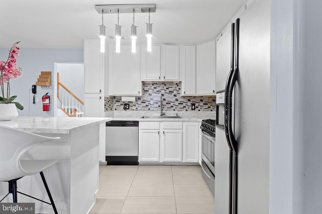 10335 Citation Way Ruther Glen, VA 22546 - Photo 10 of 47 a kitchen with kitchen island a sink appliances and cabinets