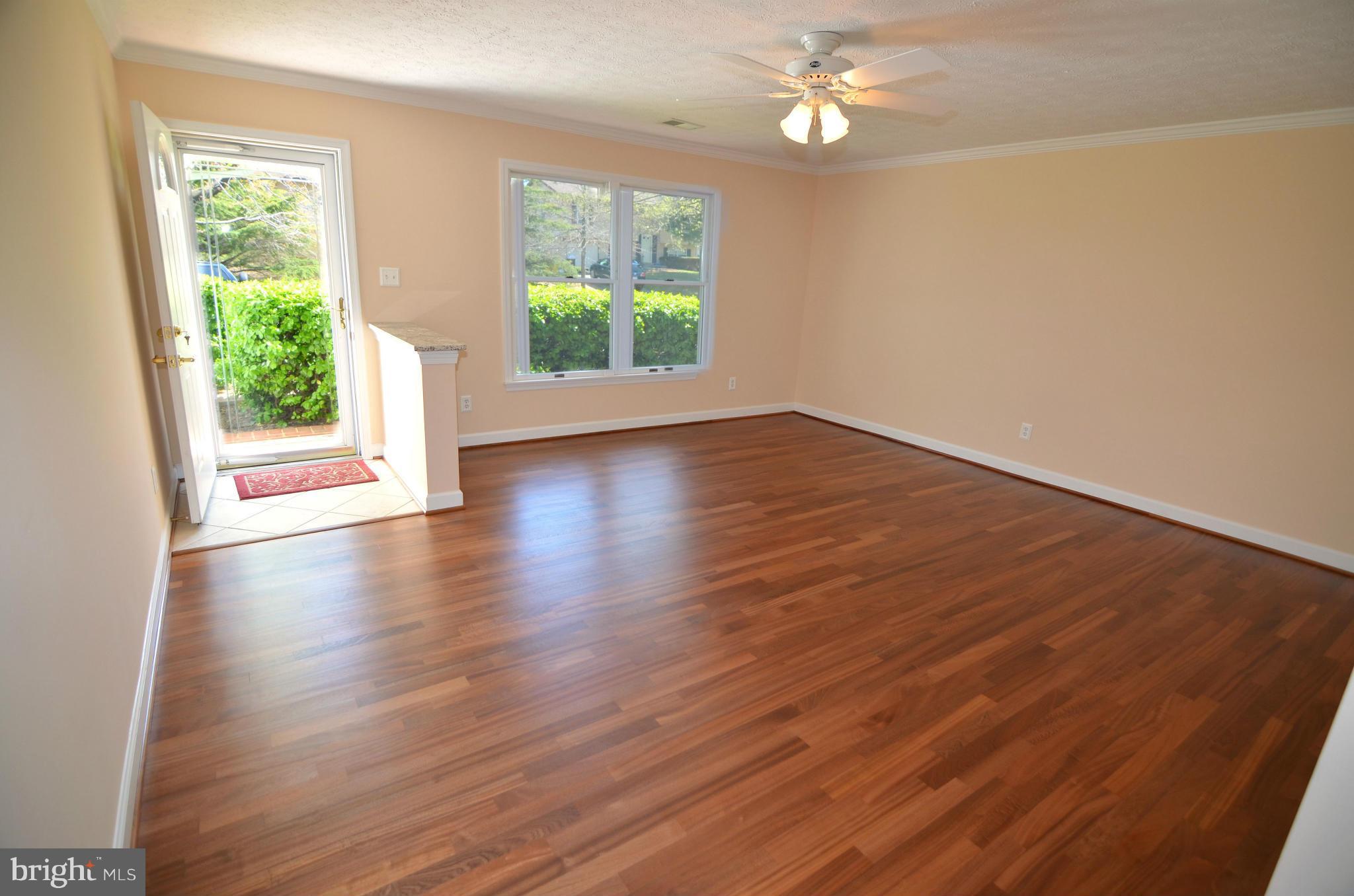 8222 Grainfield Road Severn, MD 21144 - Photo 3 of 30 an empty room with wooden floor and windows