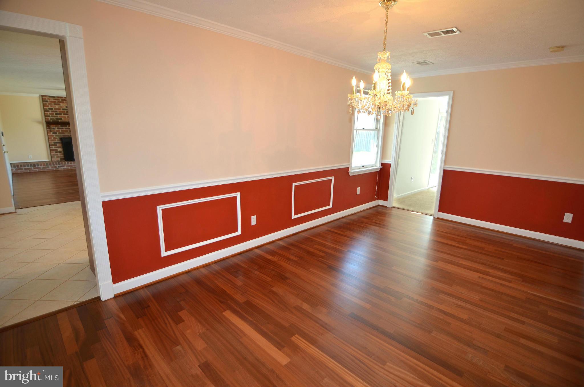 8222 Grainfield Road Severn, MD 21144 - Photo 4 of 30 a view of a room with wooden floor and chandelier